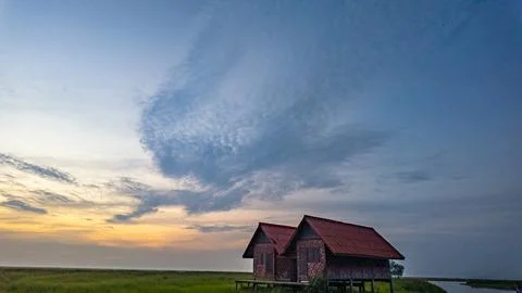 Vibrant Twilight Sky Above Rustic Thai Village Stock Photos