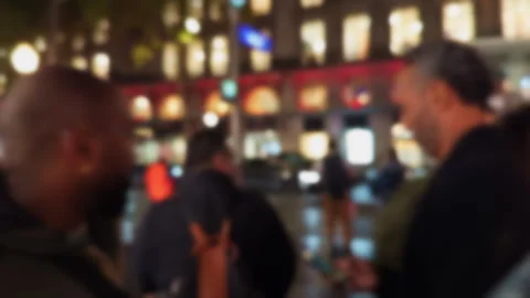 A Vibrant Urban Night Scene Featuring Several People and Shimmering City Lights Stock Footage 318554656