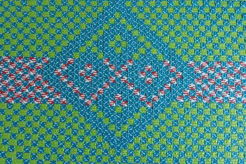 Vibrant woven plastic texture featuring colorful geometric patterns and che.. Stock Illustration