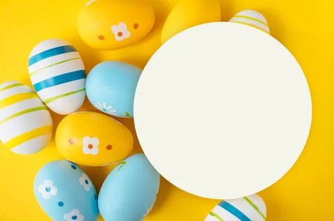 Vibrant yellow background with colorful Easter eggs Stock Photos