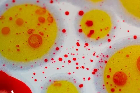 Vibrant yellow circles float amid red specks on a white background Stock Photos