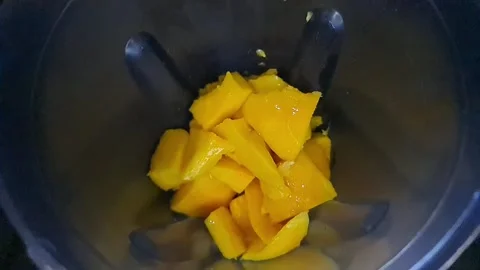 Vibrant Yellow Mango Cubes in a Green Blender/Grinder, High-Speed Slow Motion Stock Footage 316973217