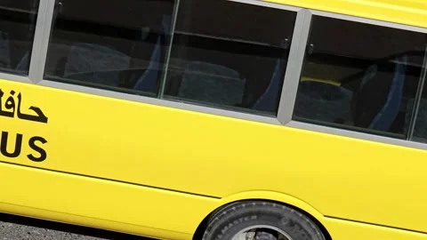 A vibrant yellow school bus, adorned with SCHOOL BUS text Stock Footage 311886810