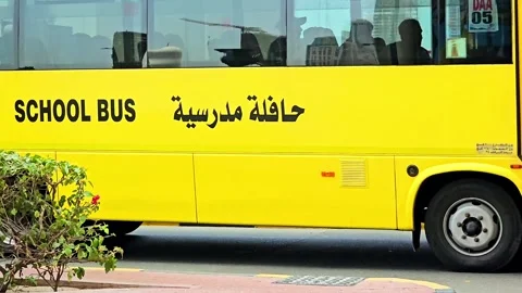 A vibrant yellow school bus, adorned with SCHOOL BUS text Stock Footage 311886953