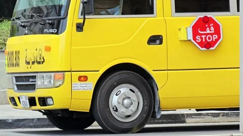A vibrant yellow school bus, adorned with SCHOOL BUS text Stock Footage 311887067