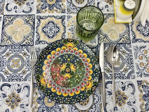Vibrantly colored plate with mandala pattern set on tablecloth Stock Photos