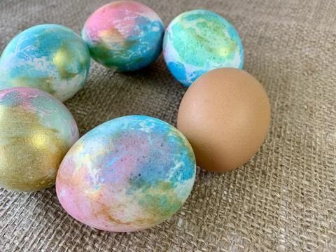 Vibrantly decorated Easter eggs in various colors are displayed in a circular Stock Photos