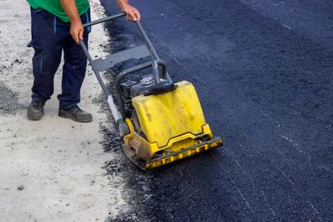 Vibrating compactor plate in action Stock Photos