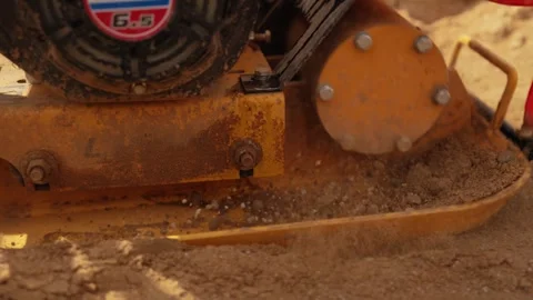 Vibratory plate compactor compacting sandy ground Stock Footage 341294858