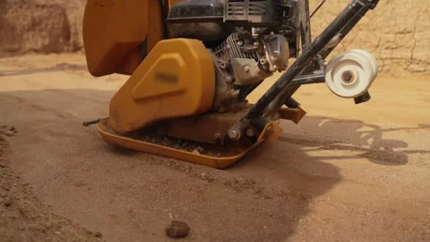 Vibratory plate compactor leveling ground at construction site Stock Footage 341294811