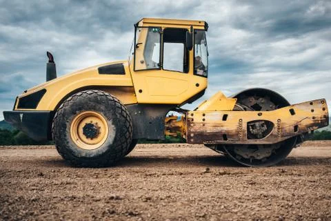 Vibratory Soil Compactor during highway construction. Industrial roadworks Stock Photos