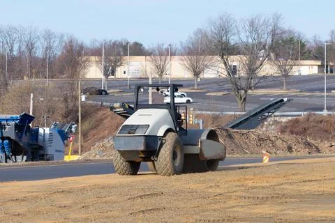 Vibratory soil compactor working on highway construction site Stock Photos