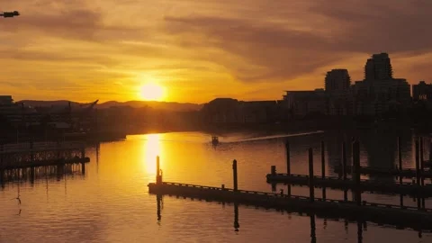 Victoria, BC, Canada – June 25, 2026: Golden sunrise over harbor cityscape Stock Footage 337653219
