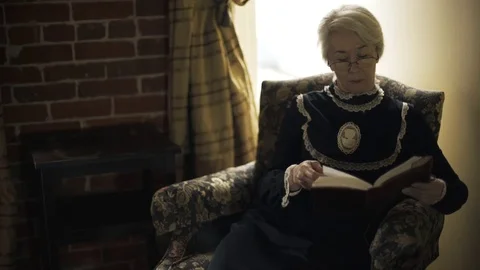 Victorian era woman reading a book or bible in her bedroom close 4k Stock Footage