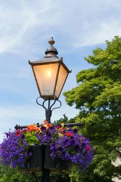 This Victorian Lamp Post Features Hanging Flower Baskets. Foto stock