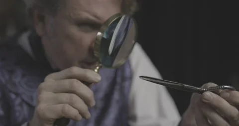 Victorian man examines an antique pair of Georgian scissors (flat) Vídeos de archivo 227908866