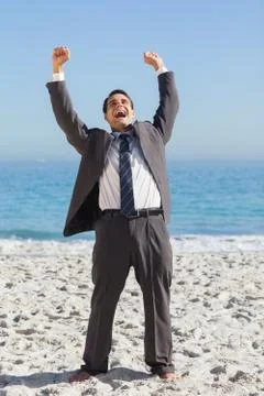 Victorious businessman in suit holding arms up Stock Photos