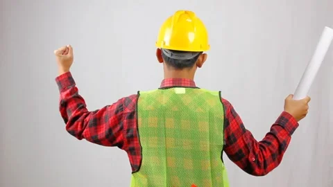 Victorious construction worker celebrating project success with blueprints Stock Footage 319968336
