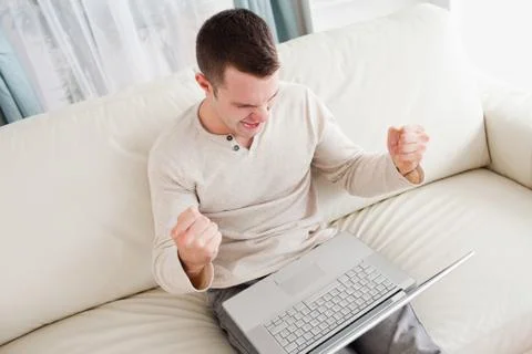 Victorious man using a laptop Stock Photos