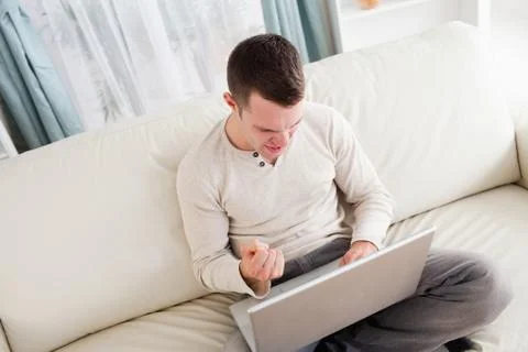 Victorious man using a notebook Stock Photos