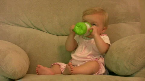 Vid011 baby with sippy in chair Stock Footage