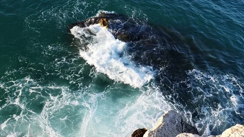 Video 4k Sea waves hitting the white rock on a beach with sand, stones and pebbl Video stock 78761358