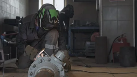 Video 4k. Welding technician in a workshop fixing large machinery with prot.. Stock Footage 282995423
