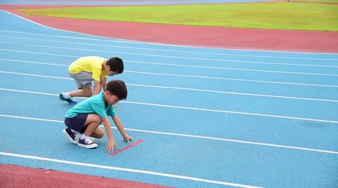 This video is about Slow motion, young Asian boy runing in blue running track Stock Footage 56713847