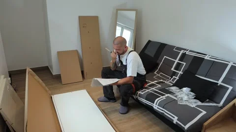 Video about a stressed man and the problem of assembling furniture with his own Stock Footage 258827818