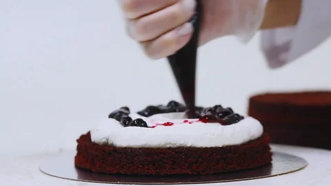 Video of adding some filling such as white cream and red jam into biscuit Stock Footage 106614560