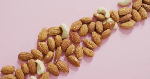 Video of almonds and nuts on pink background Stock Footage 335985026