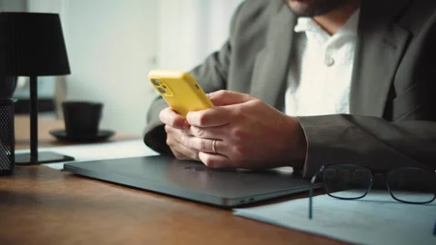 Video of an anonymous businessman using his smartphone and laptop in the office. Stock Footage 346329405