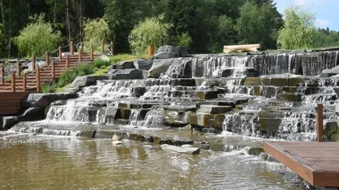 Video of an artificial waterfall, a cascade in the form of stone steps on which Stock Footage 277732950