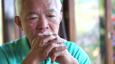 Video of Asian senior guy with hand on face thinking, worry and sad Stock Footage