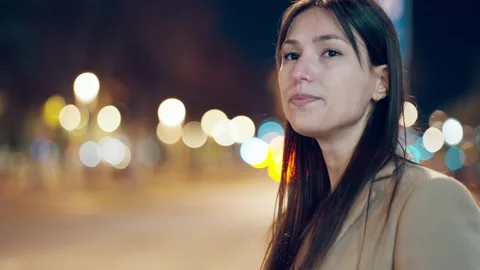 Video of attractive smiling young woman walking in the street at night. Video stock 235908053