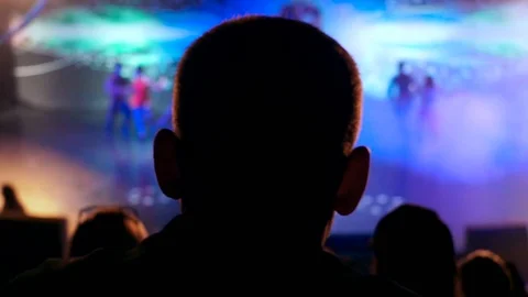 Video from the back silhouette man sitting looking performance or presentation Stock Footage 99668555