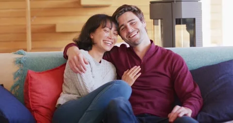 Video of back view of happy diverse couple sitting on sofa and embracing Stock Footage 337699611