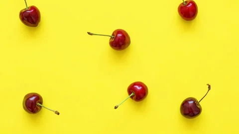 Video background of big sweet cherries on a bright yellow background. Sweet Stock Footage 270440683