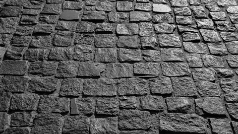 Video background of black cobbled stone road. Black or dark grey stone pavement Stock Footage 268764676