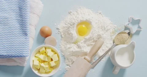 Video of baking ingredients, muffin papers, eggs and tools lying on white Stock Footage 195995839