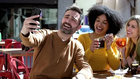 Video of bearded man taking selfie with female friends while having drink at  Stock Footage 171242236