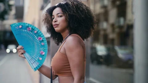 Video of beautiful fanning himself while walking through the city Stock Footage 273478646