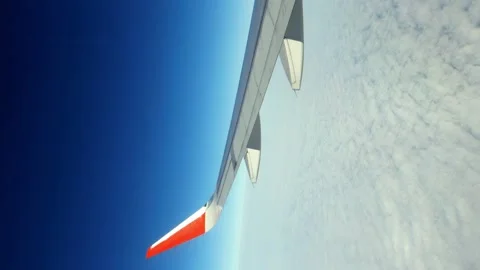VIdeo of beautiful scattered clouds of the blue sky, view from the plane window Stock Footage 166313777