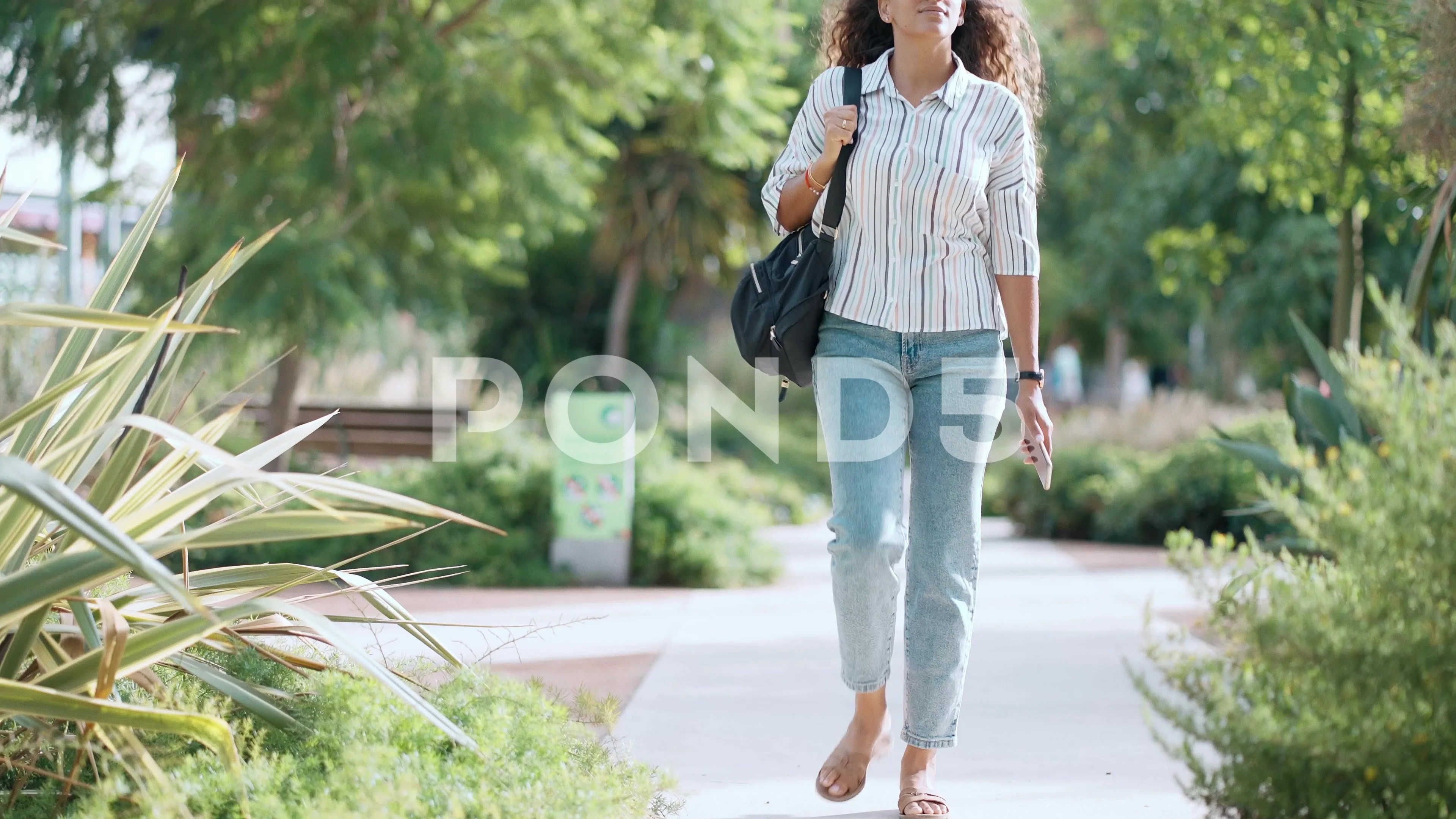 Video of beautiful woman enjoying nature while walking in a park