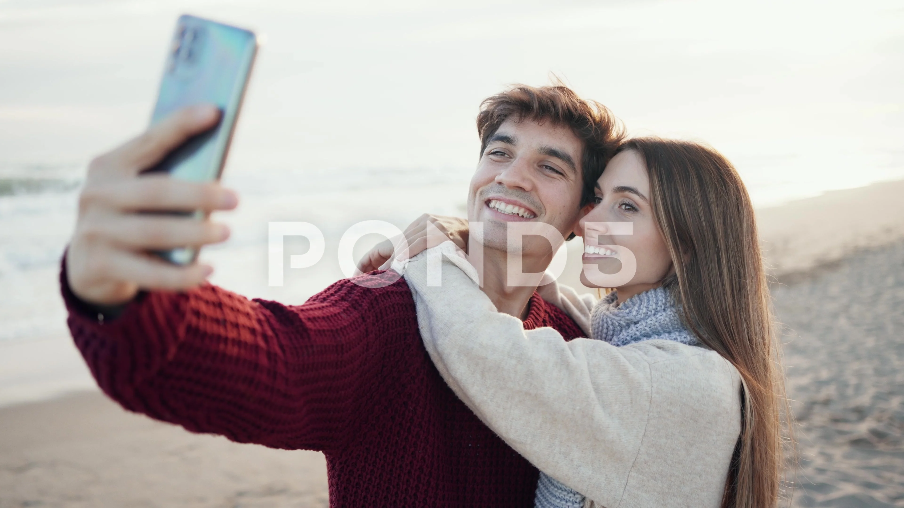 Video of beautiful young couple making photos with mobile phone in a cold  w..