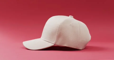 Video of beige baseball cap and copy space on red background 스톡 동영상 247354479