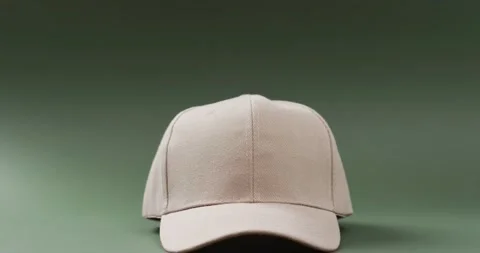 Video of beige baseball cap and copy space on green background 스톡 동영상 247354480