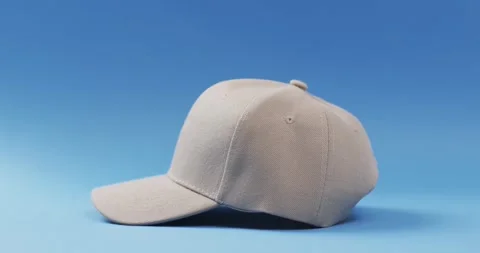 Video of beige baseball cap and copy space on blue background 스톡 동영상 247354488