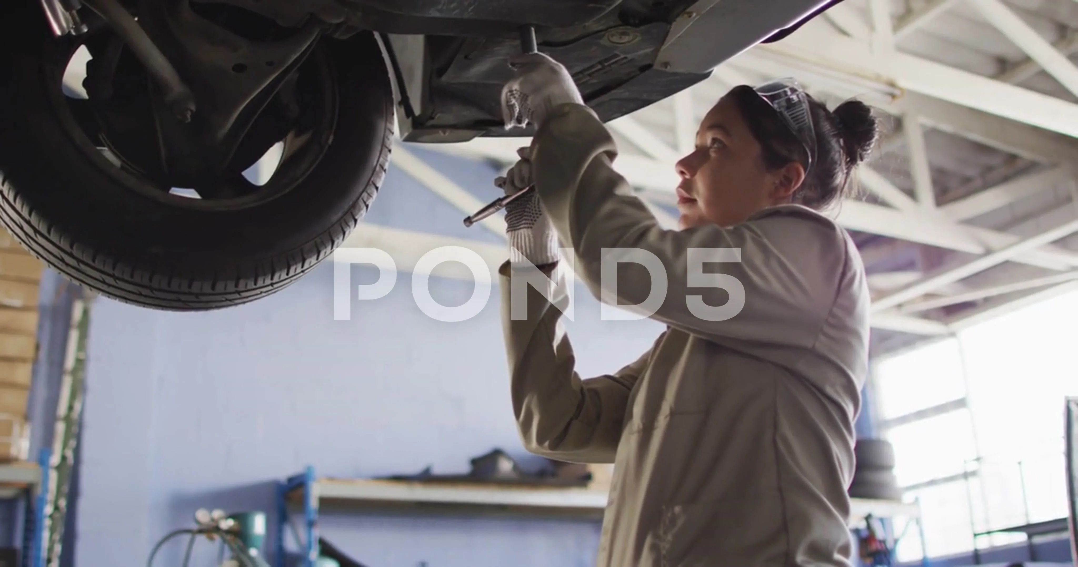 Video of biracial female car mechanic repairing car