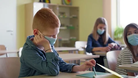 Video of bored boy sitting in a classroom during a pandemic. Stock Footage 153532287